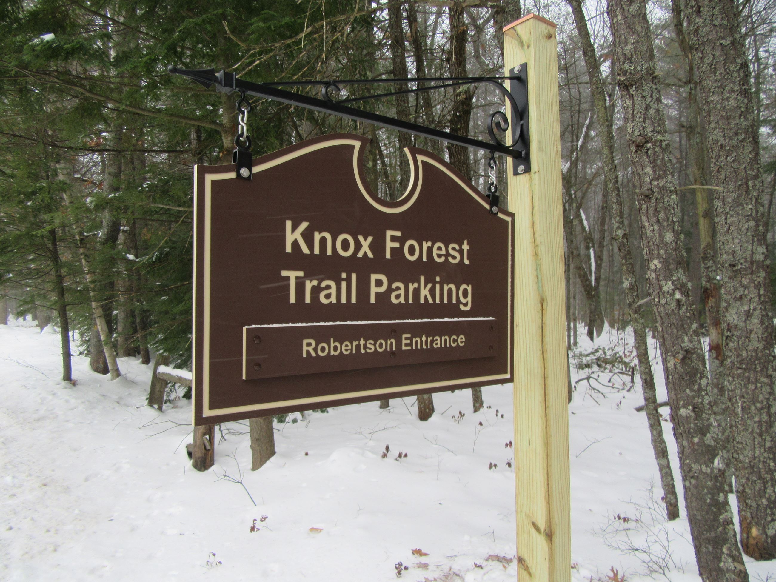 Wooden sign in the forest that says 